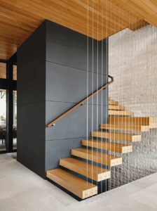 The Cove House’s floating staircase conceals a full elevator within its sculptural central column—making every floor accessible without compromising beauty.